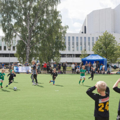 Children are playing football in the summer.
