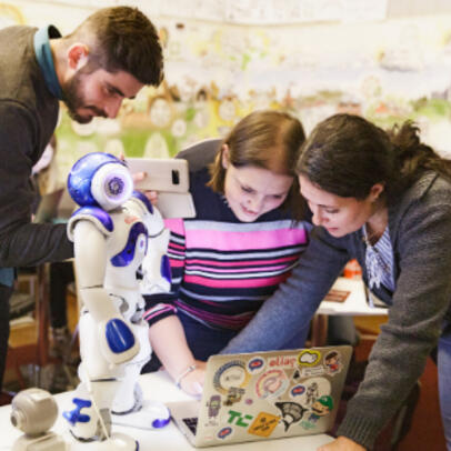 Young people at a desk working together in a library.
