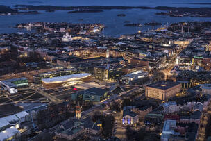 Exteriör vy av Oodi centralbibliotek i kvällsljus.