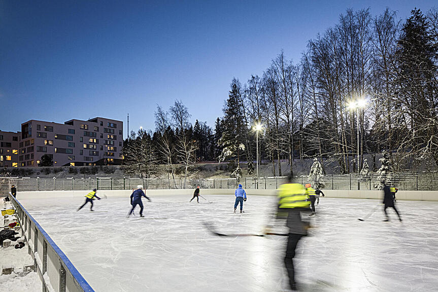 Jääkiekon pelaajia ulkokaukalossa.