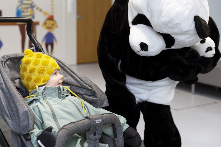 Panda katsoo lasta vaunuissa.